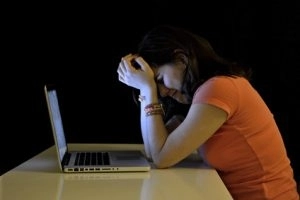 Young student woman alone at desk with computer crying desperate suffering cyber mobbing and bullying